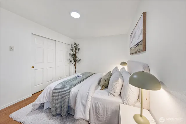 a bedroom with a bed and a painting on the wall