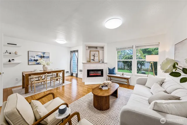 a living room with furniture a fireplace and a large window