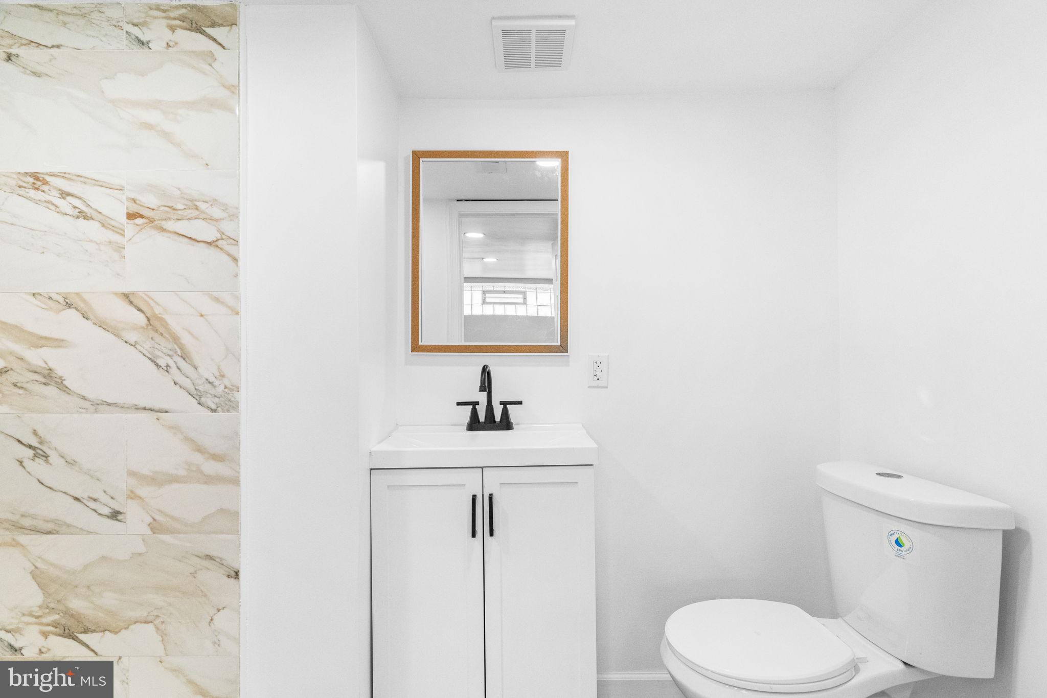 7703 Gilbert Street Philadelphia, PA 19150 - Photo 15 of 37 a bathroom with a toilet sink and mirror