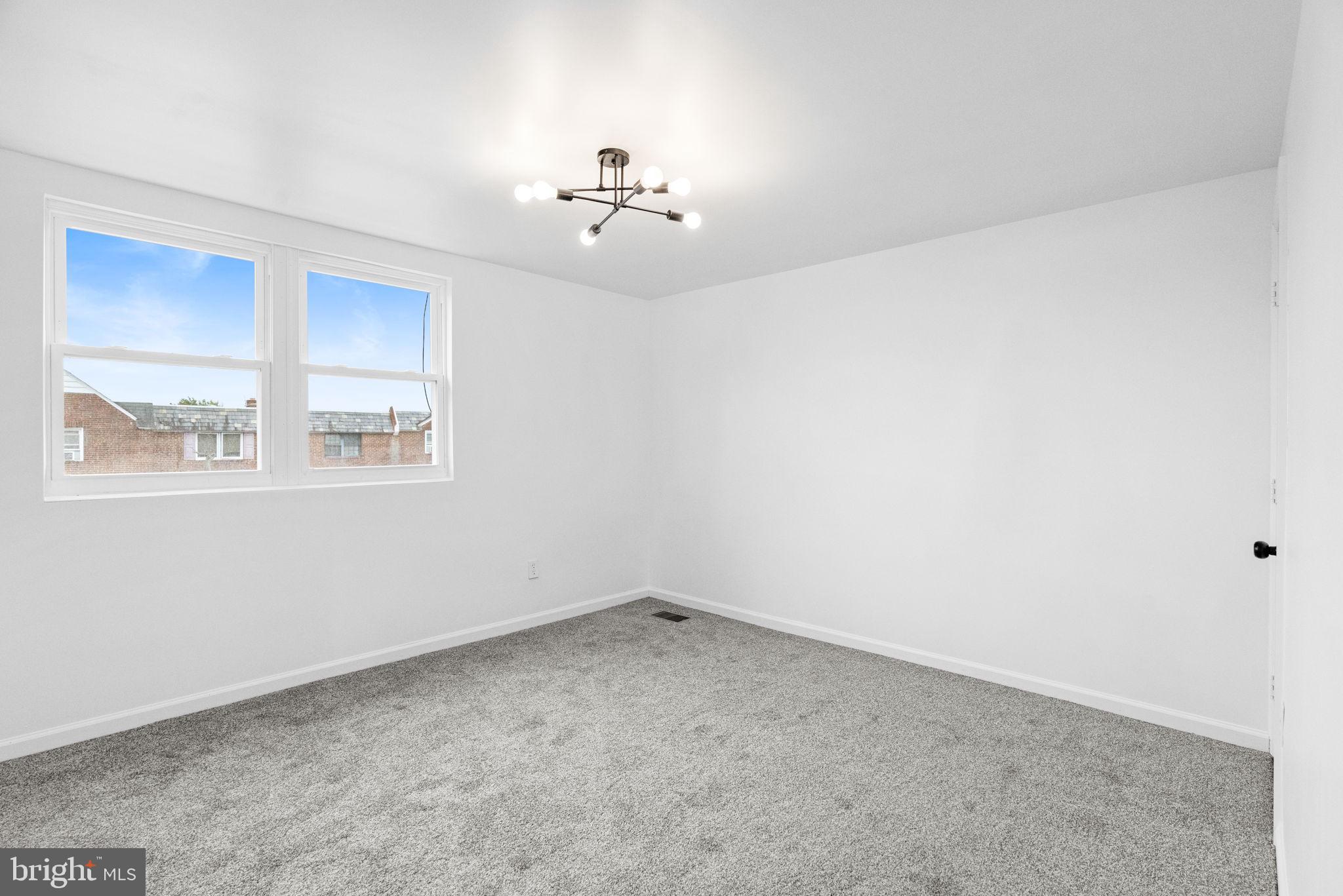 7703 Gilbert Street Philadelphia, PA 19150 - Photo 24 of 37 an empty room with windows and chandelier fan