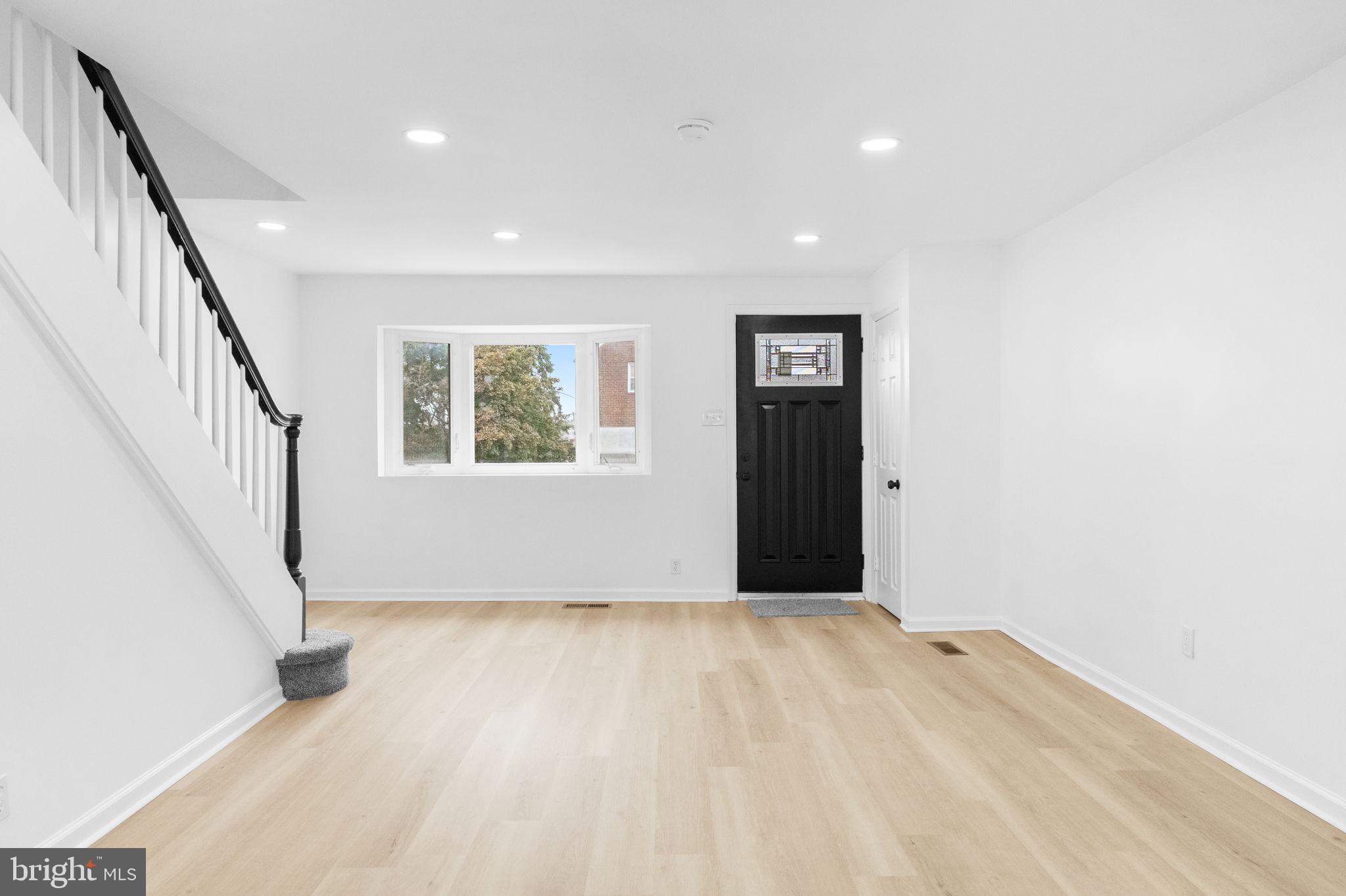 7703 Gilbert Street Philadelphia, PA 19150 - Photo 9 of 37 a view of an empty room with wooden floor and stairs