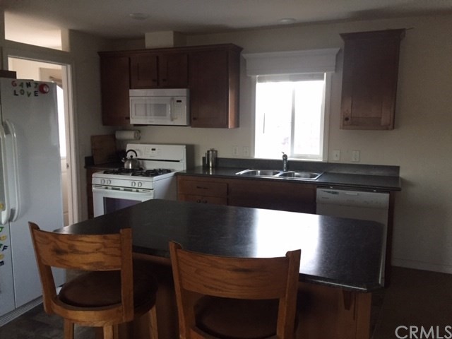 25432 Jerusalem Grde Lower Lake, CA 95457 - Photo 17 of 27 a kitchen with a table chairs refrigerator and microwave