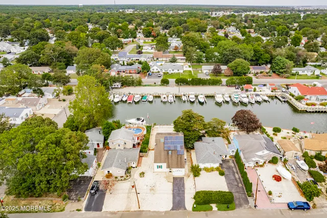 an aerial view of a city with lots of residential buildings ocean and mountain view in back