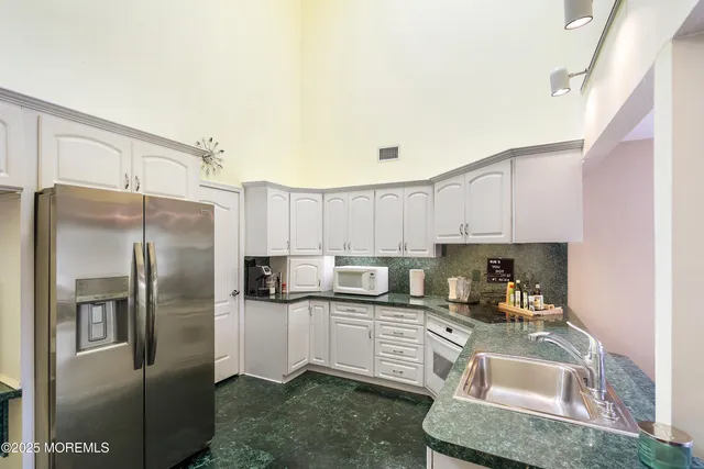 a kitchen with appliances a sink and cabinets