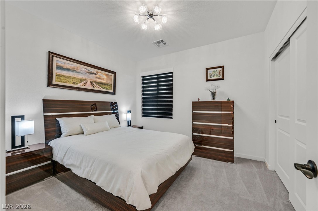 2933 Little Current Road North Las Vegas, NV 89086 - Photo 27 of 35 Plush carpeting and crisp white walls define this well-appointed sleeping sanctuary.
