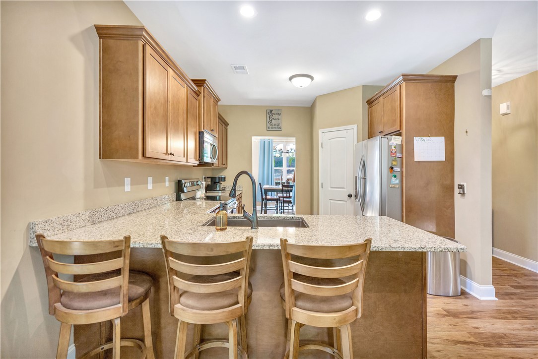3004 Cobbs Way Anderson, SC 29621 - Photo 9 of 46 Warm wood cabinetry and granite countertops define this functional kitchen space with breakfast bar seating.