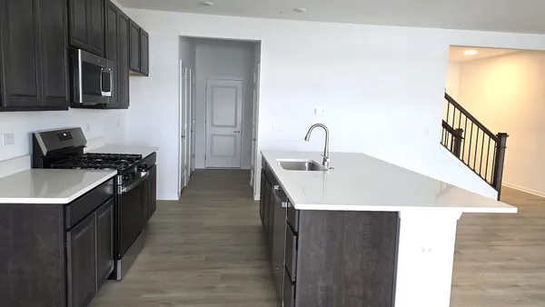 a kitchen with a sink a stove and cabinets