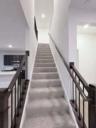 a view of staircase with lots of frames on wall and wooden floor