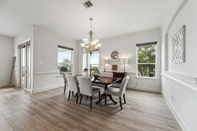 a view of a dining room with furniture a chandelier and wooden floor