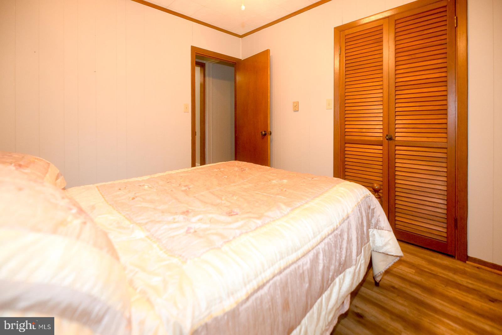 17309 Piney Point Road Piney Point, MD 20674 - Photo 16 of 38 a view of a bedroom with wooden floor and a window