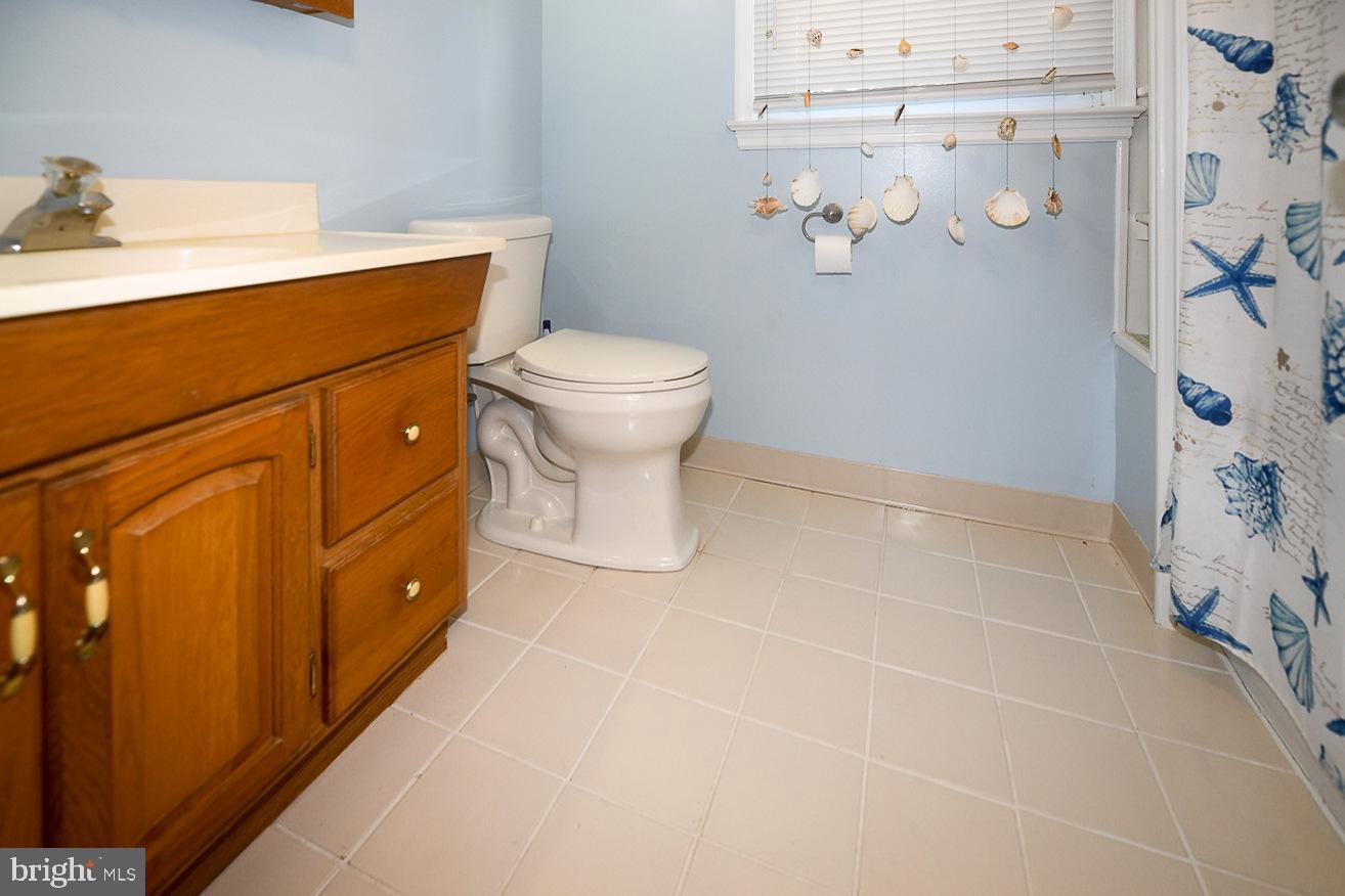 17309 Piney Point Road Piney Point, MD 20674 - Photo 18 of 38 a bathroom with a sink a toilet and vanity