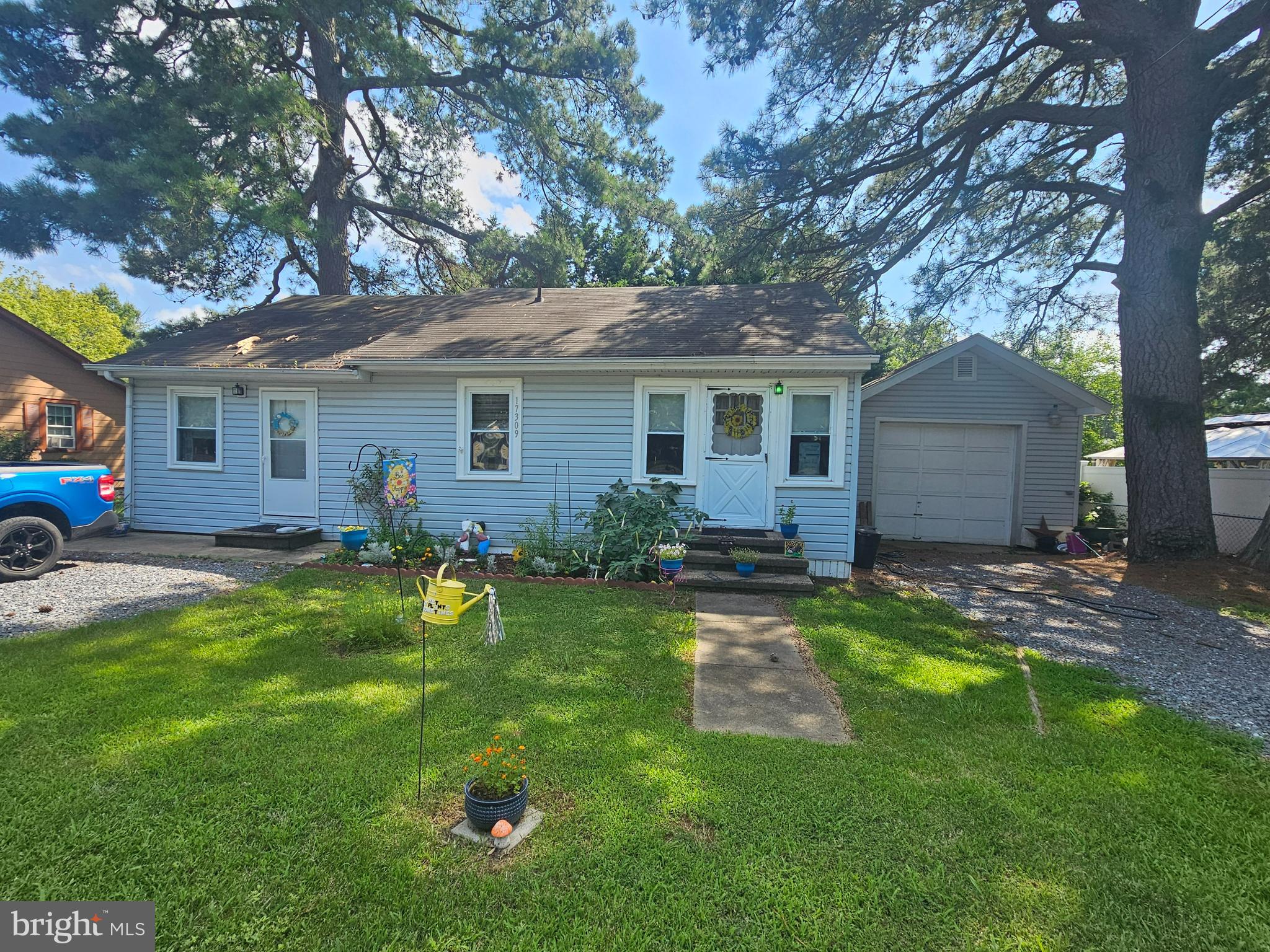 17309 Piney Point Road Piney Point, MD 20674 - Photo 23 of 38 a backyard of a house with table and chairs plants and large tree