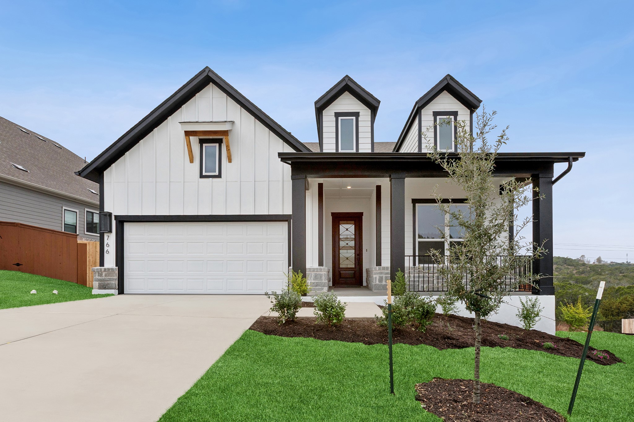 766 Iron Willow Loop Dripping Springs, TX 78620 - Photo 1 of 1 a front view of a house with a garden and plants