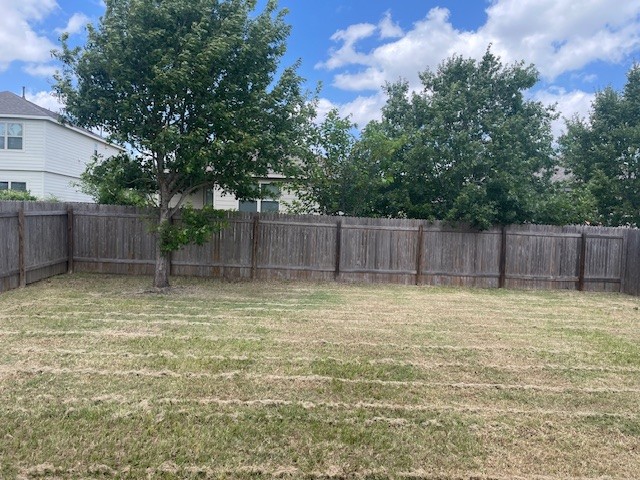 10201 Gertrudis Loop Austin, TX 78747 - Photo 23 of 24 A spacious backyard with mature trees and privacy fencing awaits your personal touch.