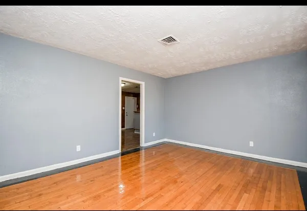 a view of empty room with wooden floor
