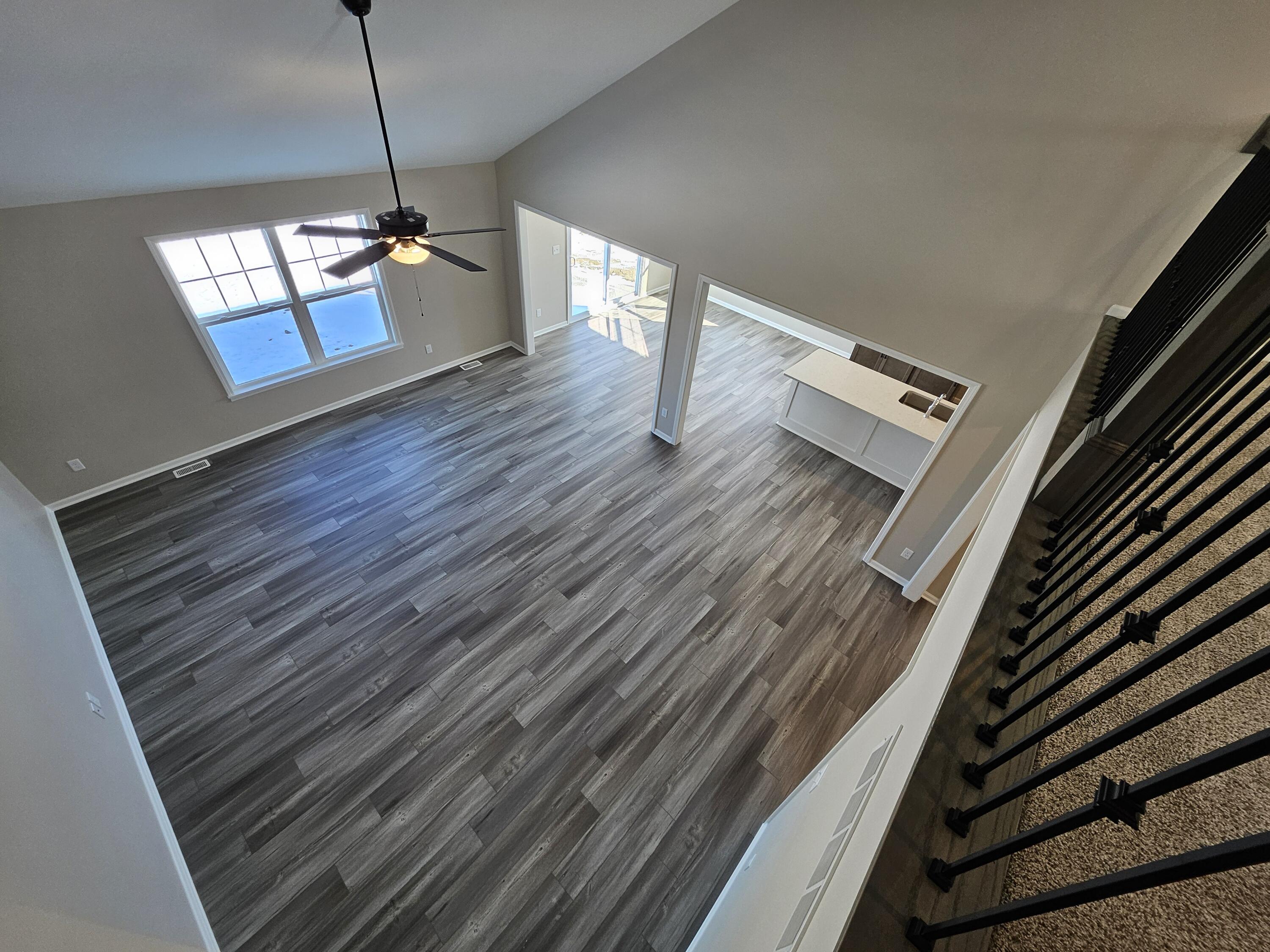 5012 Stephen Lane Lowell, IN 46356 - Photo 32 of 46 a view of a room with wooden floor staircase and a kitchen