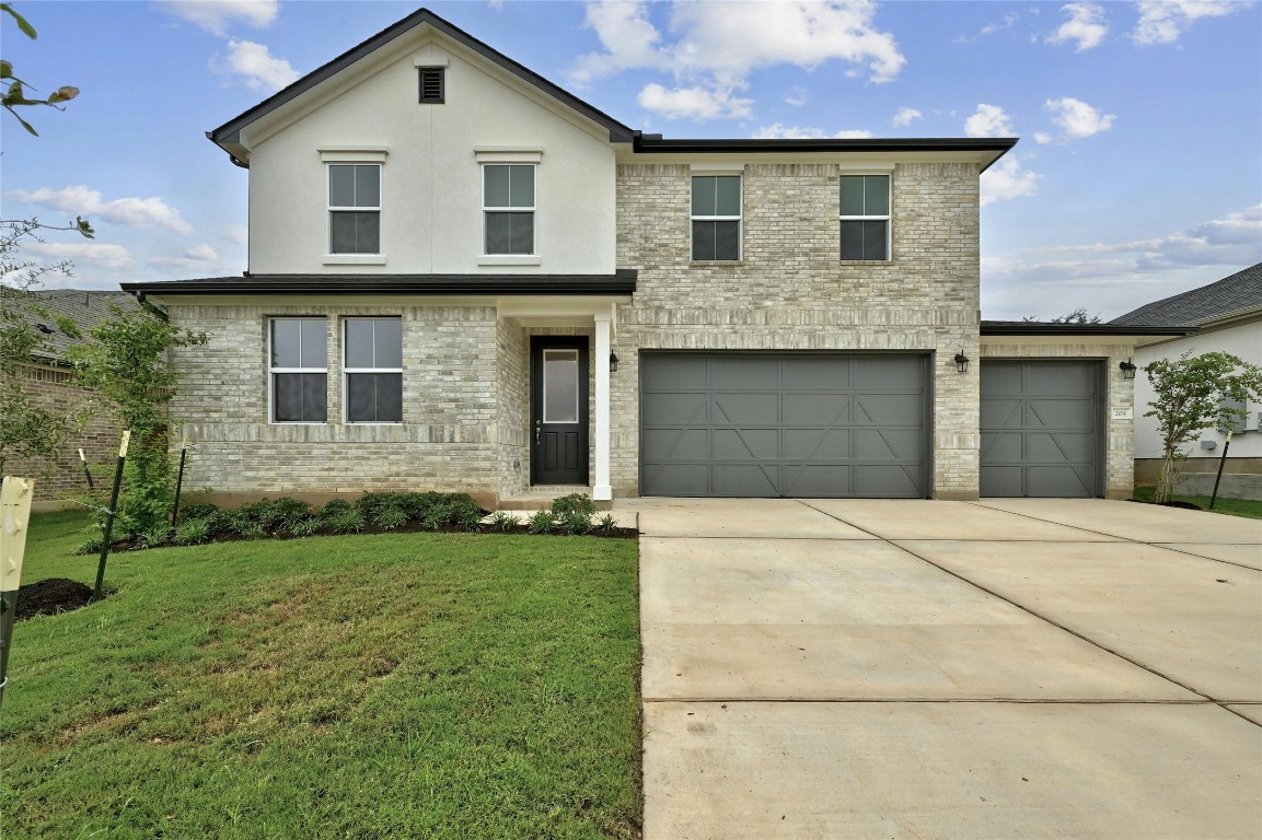 a front view of a house with a garden and garage
