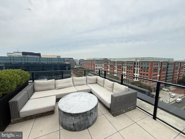 a roof deck with couches and potted plants