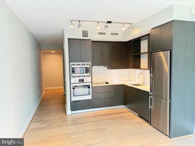 a kitchen with granite countertop a refrigerator and cabinets