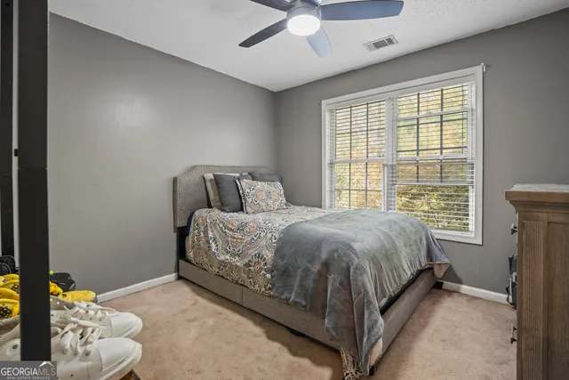 a bed sitting in a bedroom next to a window