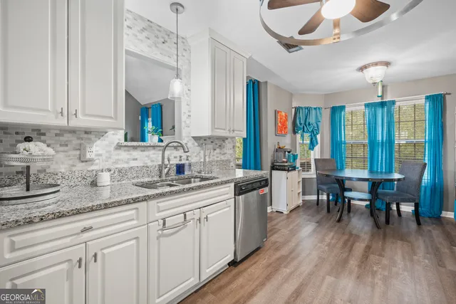 a kitchen with stainless steel appliances granite countertop a sink dishwasher cabinets and wooden floor