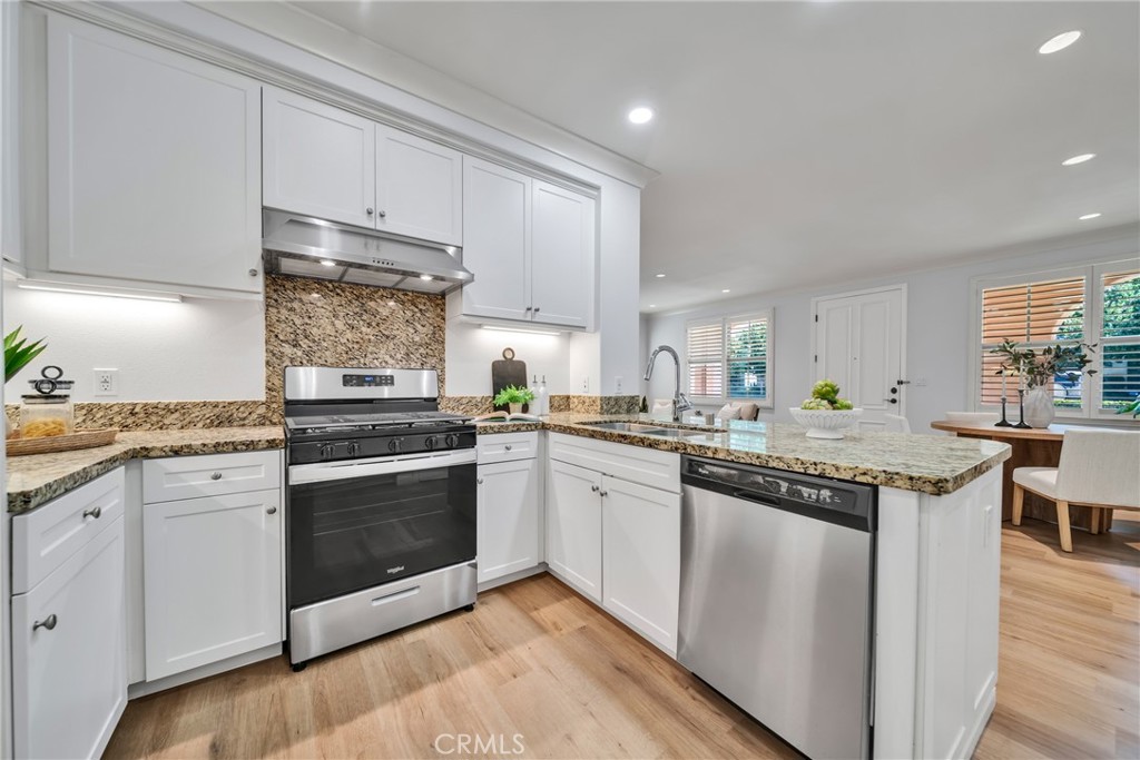 113 Mayfair Irvine, CA 92620 - Photo 12 of 31 a kitchen with granite countertop stainless steel appliances and white cabinets