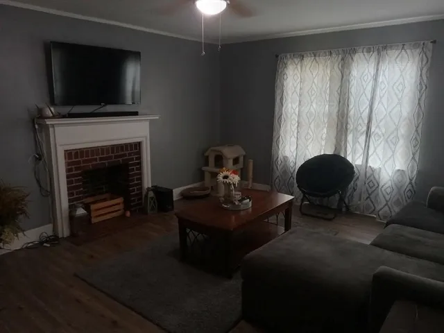 a living room with furniture a flat screen tv and a fireplace