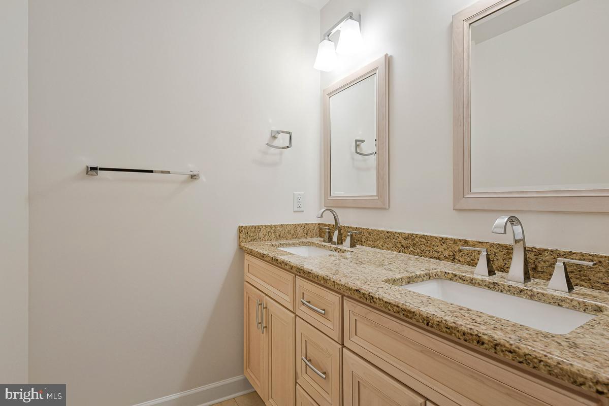 11814 Blue Spruce Road Reston, VA 20191 - Photo 38 of 56 a bathroom with a granite countertop sink and a mirror