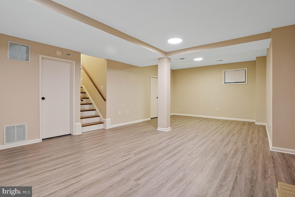 11814 Blue Spruce Road Reston, VA 20191 - Photo 42 of 56 a view of an empty room with wooden floor and stairs