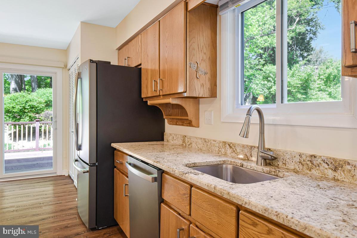 11814 Blue Spruce Road Reston, VA 20191 - Photo 7 of 56 a kitchen with granite countertop a sink a refrigerator and a granite counter tops
