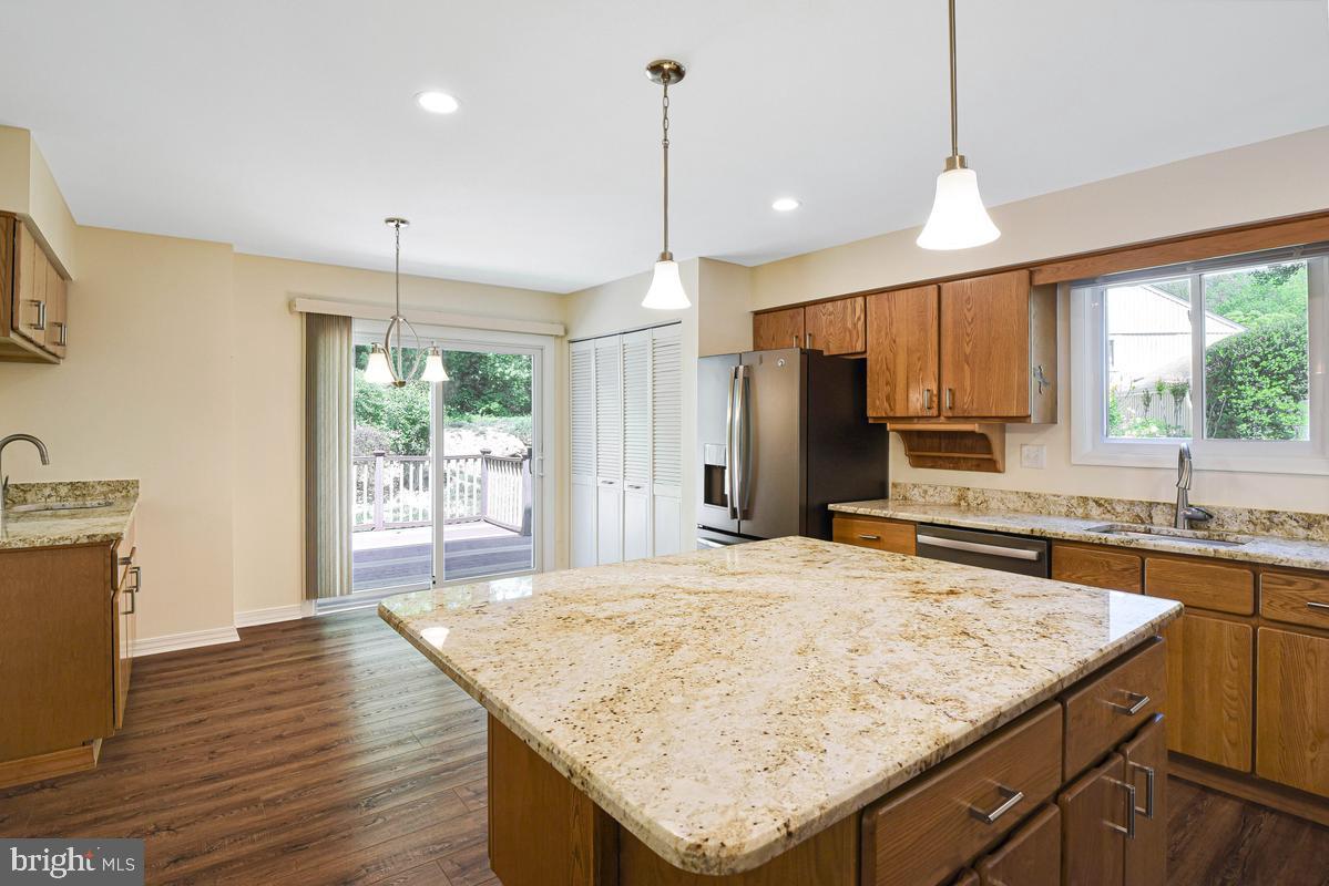 11814 Blue Spruce Road Reston, VA 20191 - Photo 8 of 56 a kitchen with granite countertop sink refrigerator and wooden floor