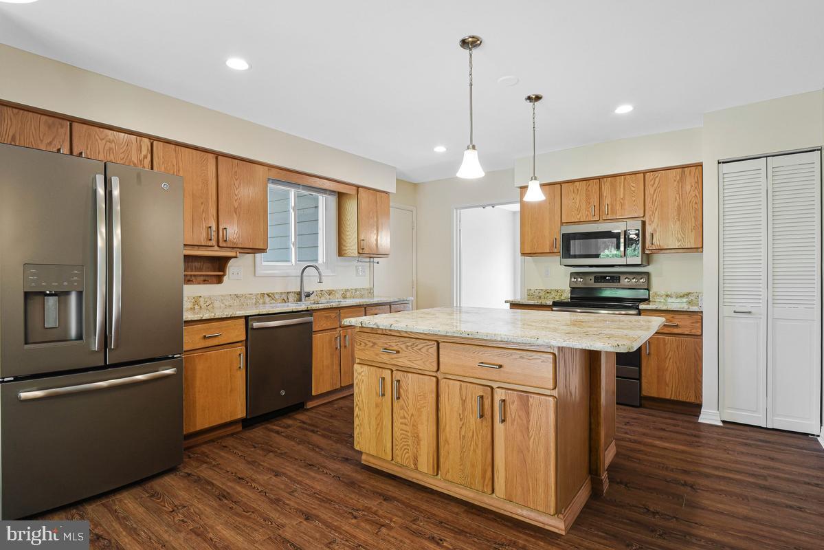 11814 Blue Spruce Road Reston, VA 20191 - Photo 10 of 56 a kitchen with stainless steel appliances granite countertop a refrigerator a sink dishwasher a stove and white cabinets with wooden floor
