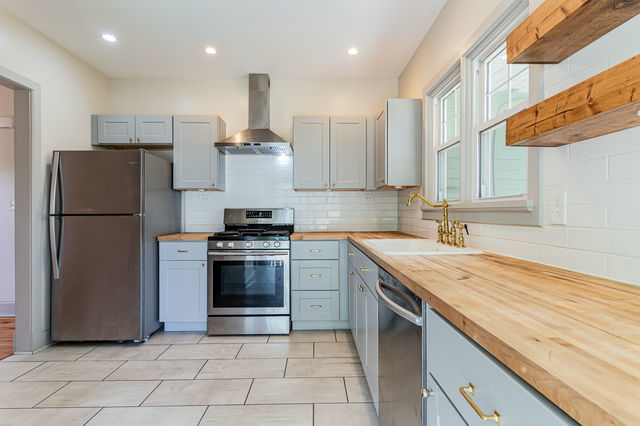 1616 West Church Street Champaign, IL 61821 - Photo 12 of 32 a kitchen with a refrigerator sink and cabinets