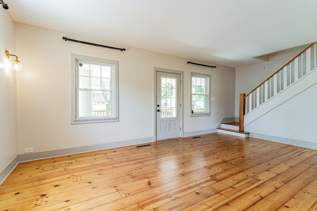 1616 West Church Street Champaign, IL 61821 - Photo 4 of 32 a view of an empty room with wooden floor and a window