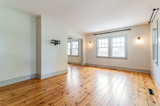 1616 West Church Street Champaign, IL 61821 - Photo 6 of 32 a view of an empty room with wooden floor and a window
