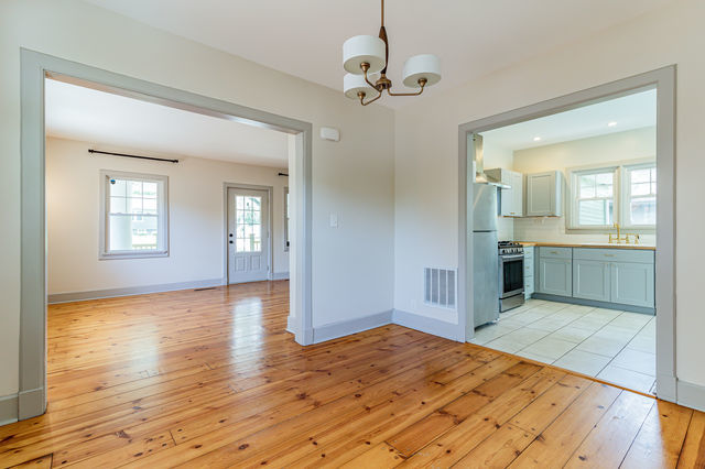 1616 West Church Street Champaign, IL 61821 - Photo 9 of 32 a view of an empty room with wooden floor and a kitchen