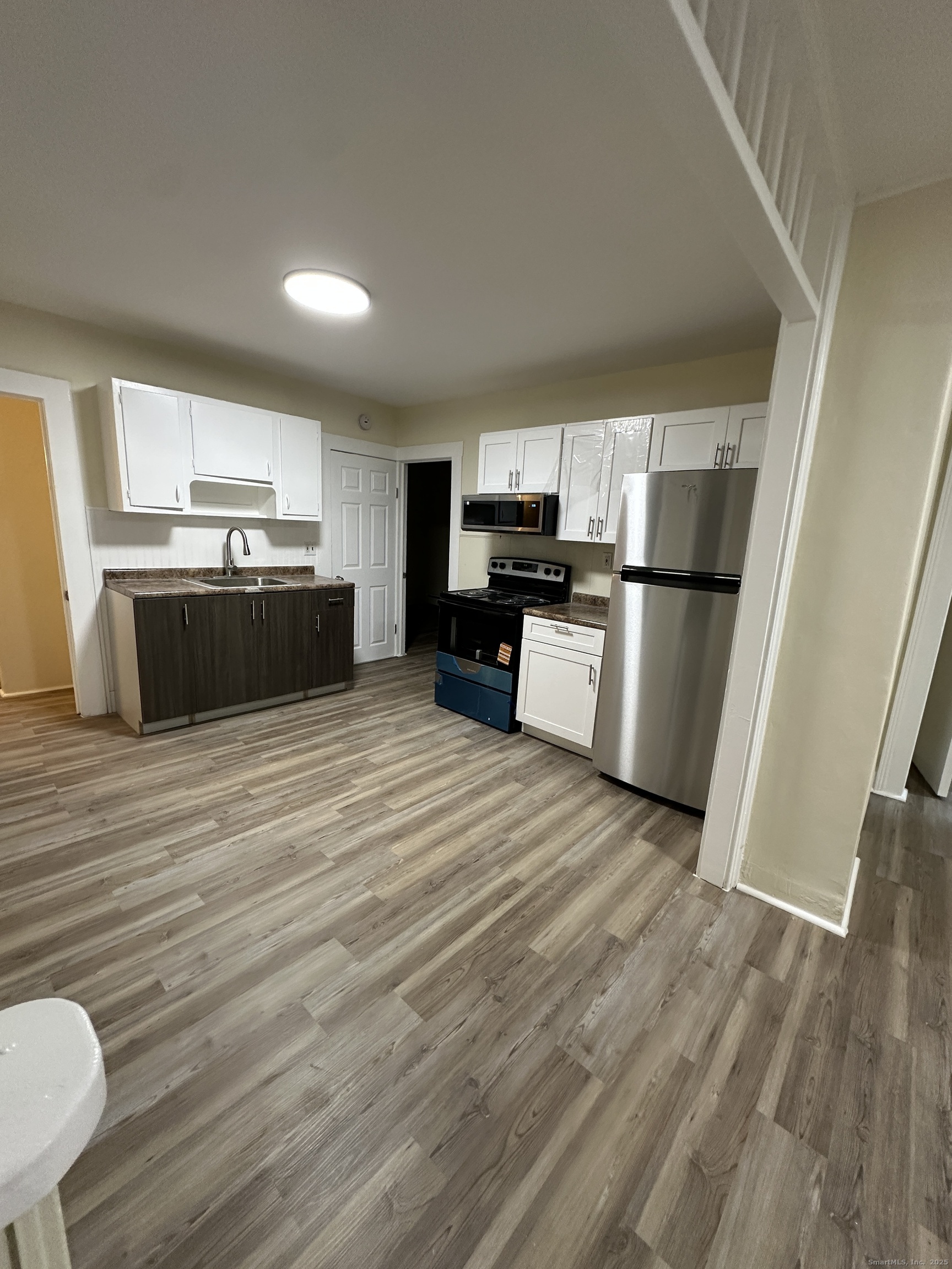 42 Spring Street New London, CT 06320 - Photo 1 of 10 a large kitchen with a stove a refrigerator and a wooden floor