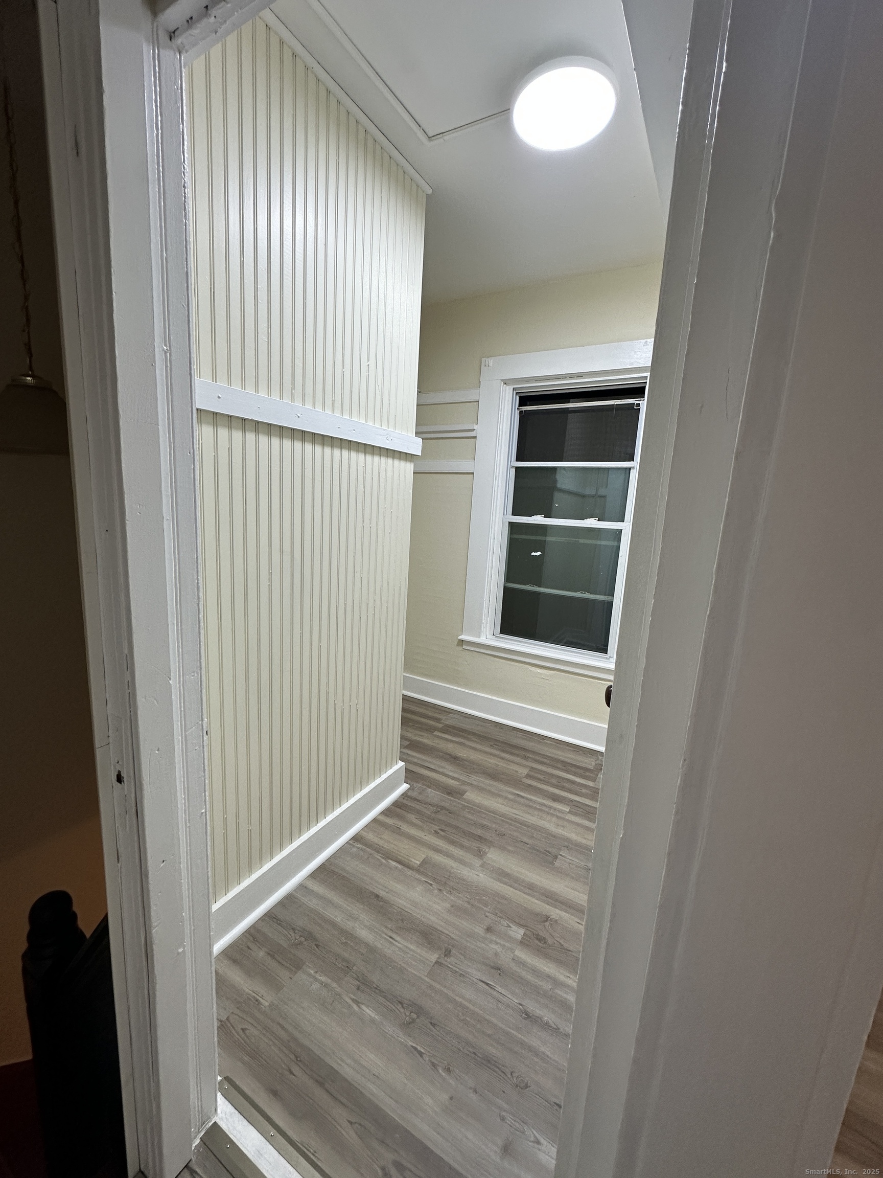 42 Spring Street New London, CT 06320 - Photo 3 of 10 an empty room with wooden floor and windows