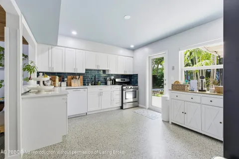 a kitchen with granite countertop white cabinets and white appliances