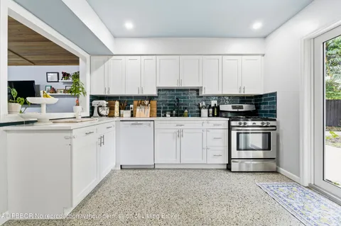 a kitchen with white cabinets and white appliances