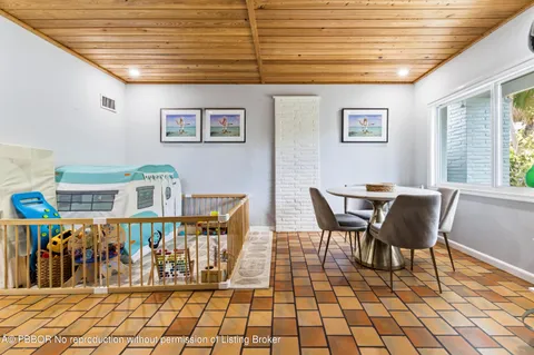 a dining room with furniture and next to a window