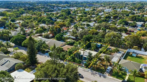 an aerial view of residential houses with outdoor space and trees