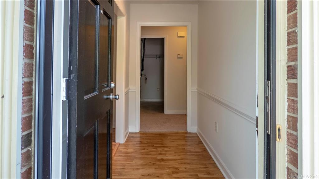 1708 Lawton Bluff Road Charlotte, NC 28226 - Photo 8 of 25 a view of a hallway with wooden floor and a bathroom