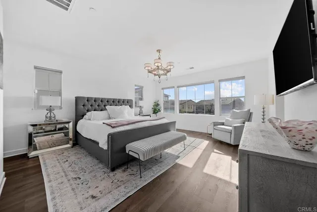 a spacious bedroom with a bed and a refrigerator