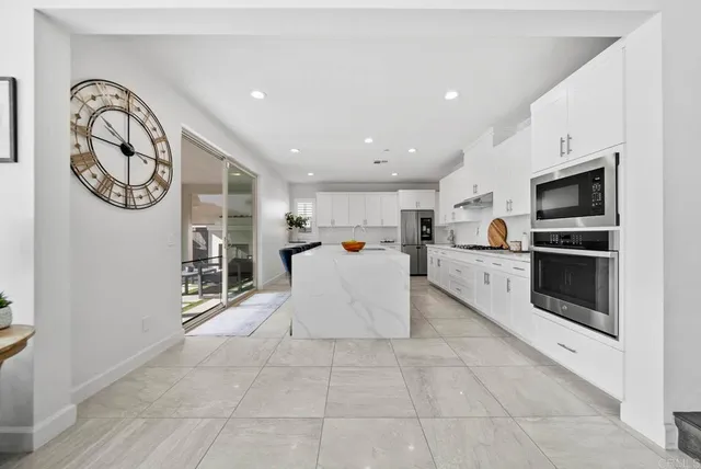 a spacious bedroom with a bed and a flat screen tv