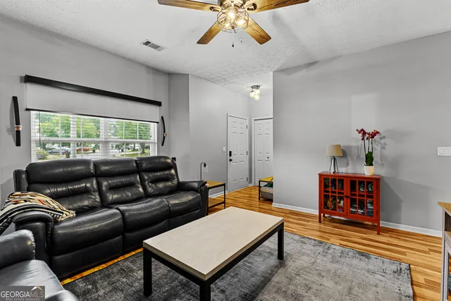 a living room with furniture a rug and a large window