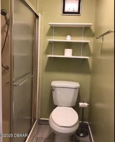 a bathroom with a toilet and a shower