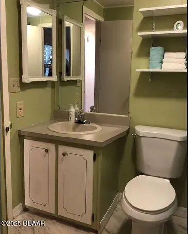 a bathroom with a granite countertop toilet sink and mirror