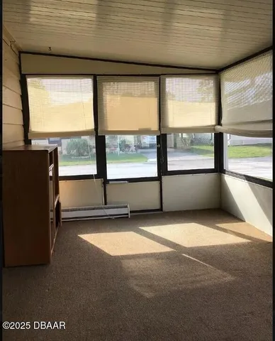 a view of an empty room with a floor to ceiling window and an outdoor view