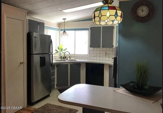 a kitchen with stainless steel appliances granite countertop a refrigerator and a sink